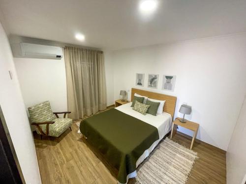 a hotel room with a bed and a chair at Casa do Barbosa in Monção