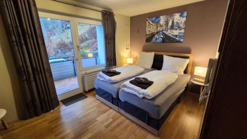 a bedroom with a bed and a large window at Villa Eleganza Monschau in Monschau