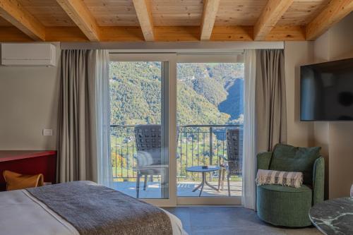 1 dormitorio con 1 cama y puerta corredera de cristal con balcón en Miramontino Mountain Suite, en Rota d'Imagna