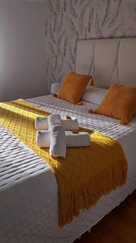 a bed with towels and pillows on it at Piso La Cumbre - CEE in Cee