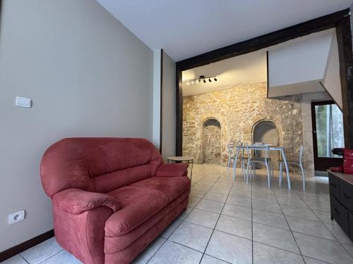 un soggiorno con un divano rosso e un tavolo di Résidence Cloche verte a Bourges