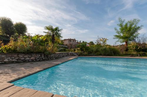 a swimming pool in a yard with a house in the background at Bagode Country Lodge in Desenzano del Garda