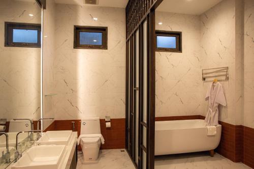 een badkamer met twee wastafels en een bad en een toilet bij Chevana Resort in Ban Doi Yao