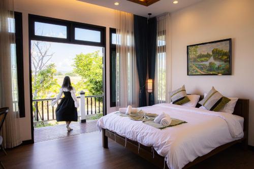 een vrouw die een slaapkamer met een groot bed binnenloopt bij Chevana Resort in Ban Doi Yao