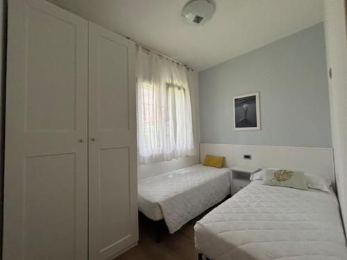 een slaapkamer met twee bedden en een raam bij Villaggio Michelangelo in Bibione