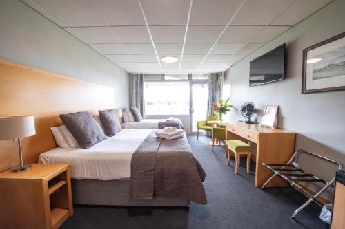a hotel room with a bed and a desk at Headingley Stadium Hotel in Leeds