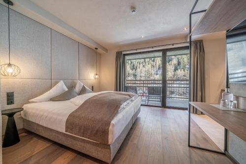 a bedroom with a bed and a large window at Edelweiss echt-charmant in Sölden