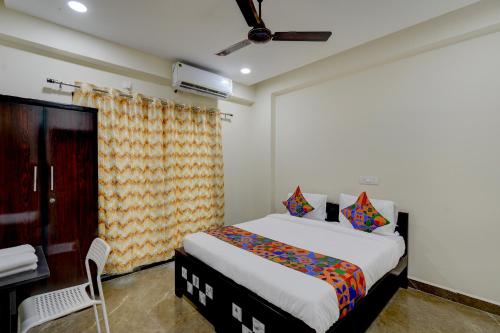 a bedroom with a bed and a chair in it at FabHotel Heaven 75 in Hyderabad