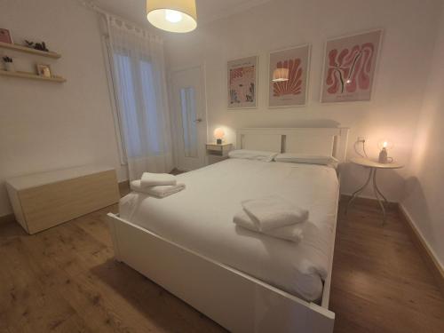 Un dormitorio blanco con una gran cama blanca con toallas. en 659A by R2R Apartmento céntrico para 3 personas, en Oviedo