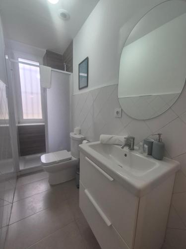 Un baño con lavabo, inodoro y espejo. en 659A by R2R Apartmento céntrico para 3 personas, en Oviedo