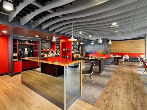 a bar in a restaurant with red walls at ibis Brighton City Centre - Station in Brighton & Hove