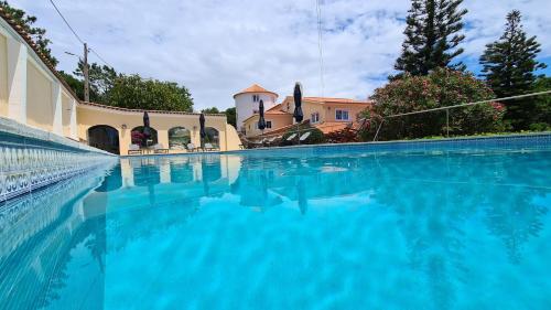 a large swimming pool in front of a building at Quinta do Cabo Guesthouse in Sintra