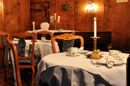 Hotel Ansitz Kandelburg في مولباخ: غرفة طعام بطاولتين و كرسيين مع شموع
