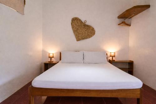 un letto in una camera con due luci sul muro di Masayana a El Nido