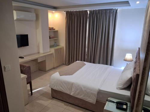 a bedroom with a bed and a desk and a television at Beirut Hotel 1 in Amman