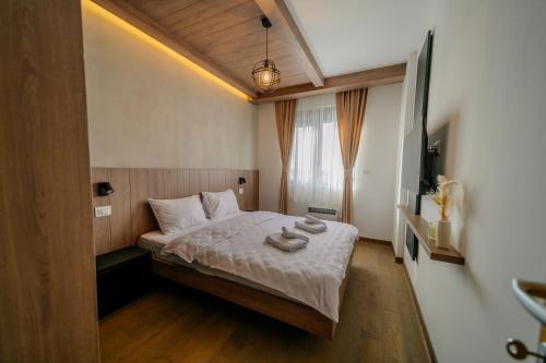a bedroom with a bed with towels on it at Zlatibor Pine & Peak in Zlatibor