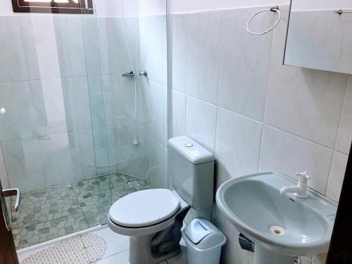 a bathroom with a toilet and a shower and a sink at Residencial Camirys in Itapoa