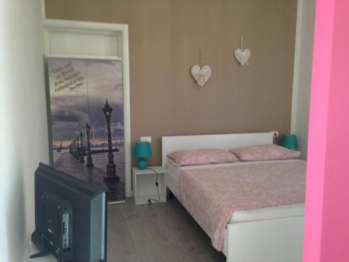 a bedroom with a bed and a flat screen tv at appartamento giorgia in Schio