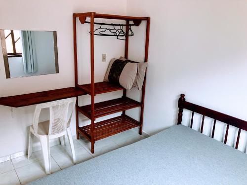 a bedroom with a bed and a mirror and a chair at Residencial Camirys in Itapoa