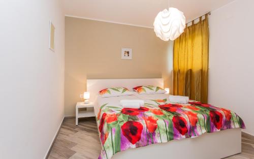 een slaapkamer met een bed met een kleurrijk dekbed bij Sunrise Apartment Risika in Risika