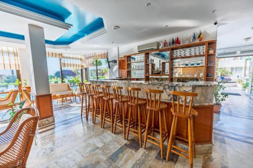 un ristorante con un bar con sedie e tavoli di Çidihan HOTEL a Kusadası