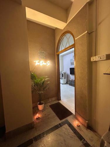 a hallway with a door with a potted plant and lights at The Dan Si in Guwahati