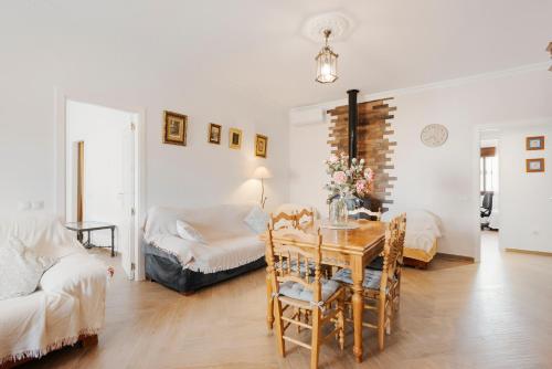ein Wohnzimmer mit Tisch und ein Schlafzimmer in der Unterkunft Casa Miró in Humilladero