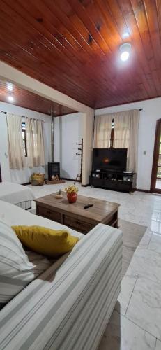 un ampio soggiorno con un divano e un tavolo di Casa Flor 2- Centro vista p o Rio a Nova Friburgo
