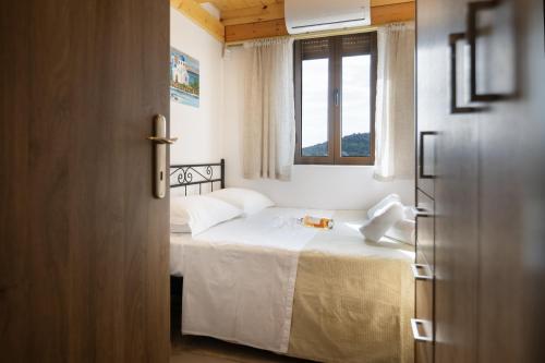 a bedroom with a white bed with a window at Seaside Stone Retreat in Salamina