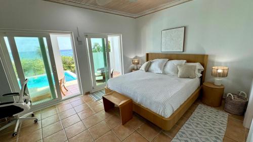 a bedroom with a bed and a view of the ocean at 8 Bedroom Ocean Front in Eleuthera Double Bay with pool in Savannah Sound