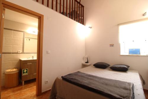 una camera da letto con un letto con due cuscini sopra di Sentinela Place a Azinhal