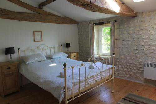 ein Schlafzimmer mit einem Bett und einem Fenster in der Unterkunft Le Font remy in Mortagne-sur-Gironde