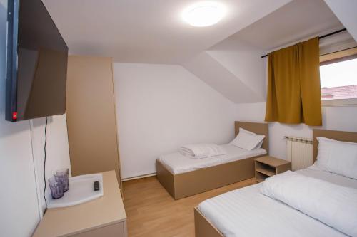 una piccola stanza con due letti e una finestra di Casa Andrea a Otopeni