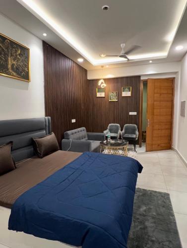 een slaapkamer met een bed en een woonkamer bij Eden Suite in Noida