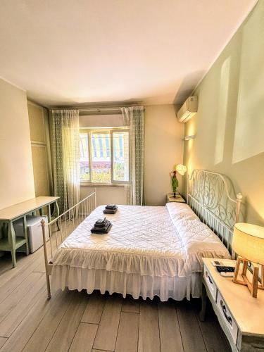 a bedroom with a bed and a table and a window at Il Sole in Terrazza - A due Passi dal Mare - Private Garden and Parking in Cinquale