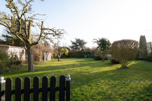 een achtertuin met een hek en een tuin met een boom bij Tuttelduven in Bisdorf
