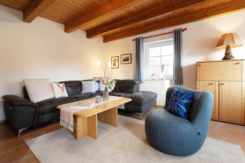 een woonkamer met een bank, een tafel en stoelen bij Tuttelduven in Bisdorf