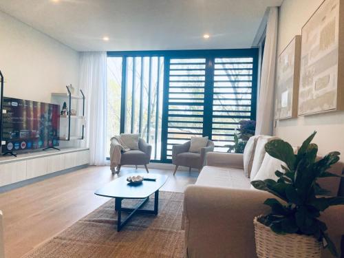 a living room with a couch and a table at Macquarie Park Station,2BR, 4 Beds,Parking,Swimming Pool in Sydney