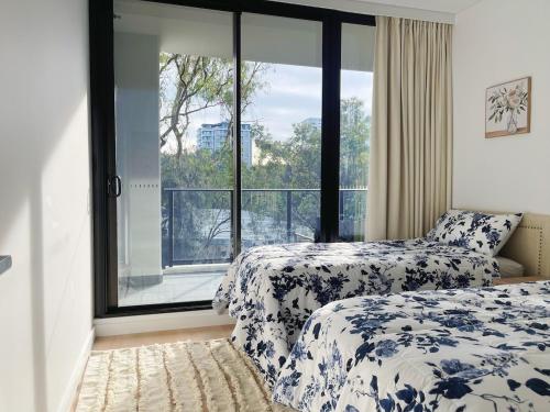 a bedroom with two beds and a large window at Macquarie Park Station,2BR, 4 Beds,Parking,Swimming Pool in Sydney