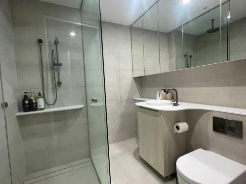 a bathroom with a shower and a toilet and a sink at Macquarie Park Station,2BR, 4 Beds,Parking,Swimming Pool in Sydney