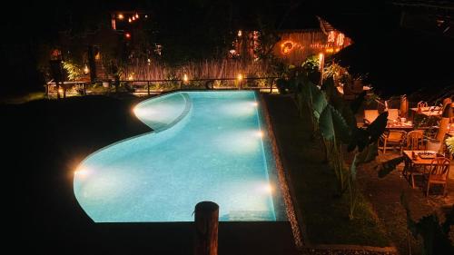 an empty swimming pool at night with lights at The Elephant Next-Door in Udawalawe