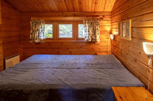 een slaapkamer met een bed in een blokhut bij Mökki Syrjälä in Puumala