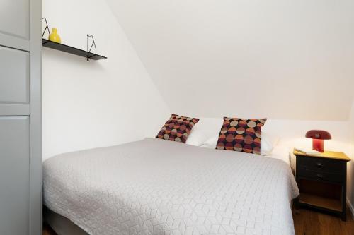 een witte slaapkamer met een bed en een nachtkastje bij Gerberhof 1 in Plön