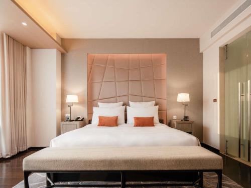 a bedroom with a large white bed with two pillows at VIE Hotel Bangkok - MGallery Collection in Bangkok
