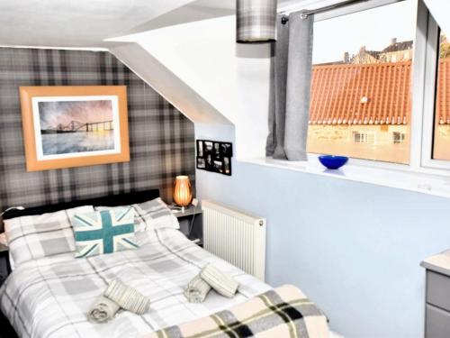 een slaapkamer met een bed en een raam bij 1 Bed in St Monans 41693 in Saint Monance
