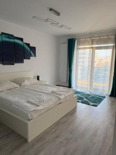 a bedroom with a large bed and a large window at Modern Stay in Şelimbăr
