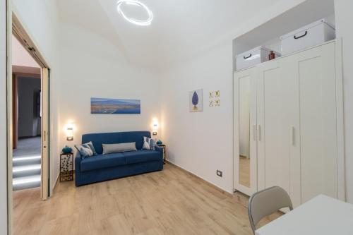 un soggiorno con un divano blu e uno specchio di Costa Apartment a Catania