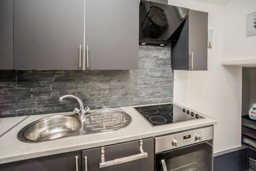 a kitchen with a sink and a stove at Cottage hide-out in Kirkheaton