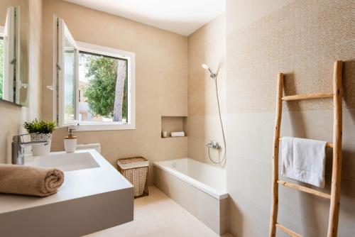 une salle de bain avec une baignoire blanche et un lavabo dans l'établissement Villa Jose, à Cala Blanca