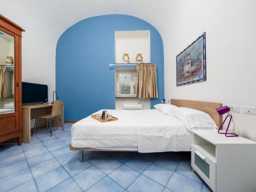 a bedroom with a bed and a desk and a tv at Ficus Home - De Vivo Realty in Sant'Agnello